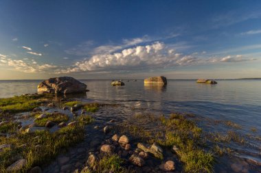 Baltık sahili taşları ve güzel bir günbatımı ile, bir kartpostal için arka plan olarak uzun pozlama fotoğrafı