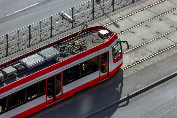 Kentsel kırmızı modern tramvay tren yolu boyunca ilerliyor. Vatandaşların ekolojik ve sosyal ulaşımı
