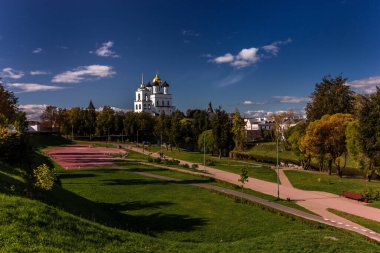 Pskov Kremlin 'in açık bir yaz gününde nehir köprüsünün üzerindeki görüntüsü. Bulutlu mavi gökyüzü pürüzsüz bir su yüzeyine yansıyor..