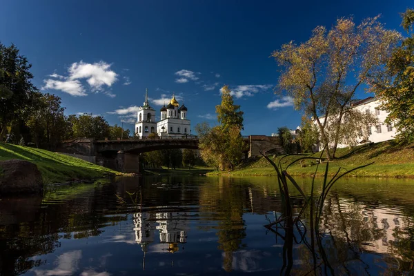 夏天晴朗的日子里 普斯科夫克里姆林宫在城市河边的桥上俯瞰着 蓝色明亮的天空 云彩映衬在光滑的水面上 — 图库照片