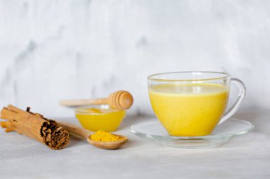 Gri arka planda cam bardaktaki altın süt. Hindistan 'dan sağlıklı bir içecek.. 