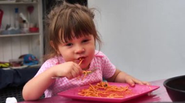 Tatlı küçük kız spagetti yiyor.