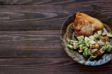 Kızarmış domuz eti, sebze salatası ve salatalık ve mayonez renginde ahşap masa. Yüksek kalite fotoğraf