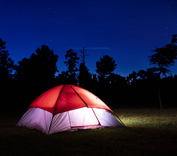 Звёзды над освещенной нейлоновой палаткой, расставленной в Северной Каролине
