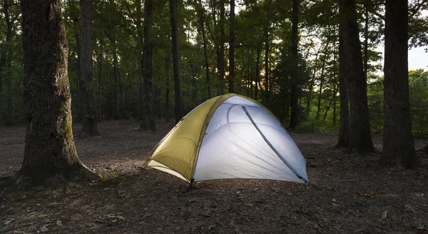 Sun setting over a well lit nylon tent in North Carolina