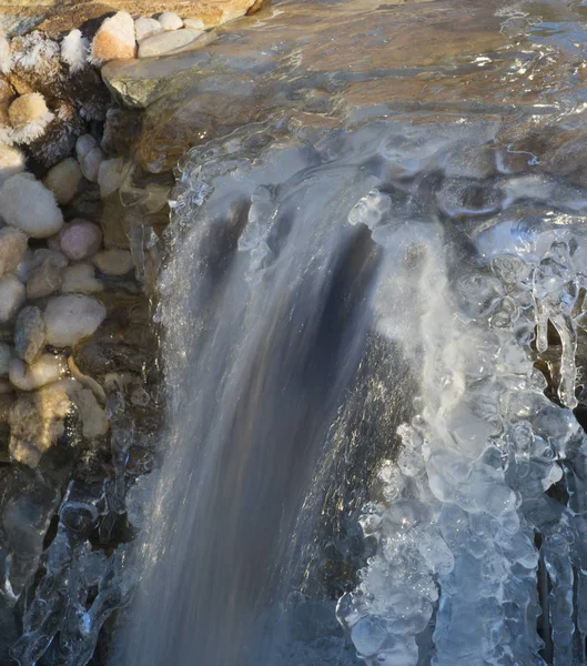 氷の上に 両側の厚いコートにもかかわらずまだ実行されている滝 — ストック写真