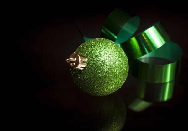 Leuchtend Grüne Schleife Und Weihnachtsschmuck Auf Schwarzem Hintergrund — Stockfoto