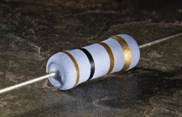 Resistor with wire leads on a dark stone background