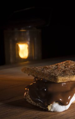 Smore arkadan parlayan bir kamp fener ile