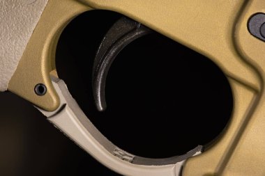 Bir Ar-15 bir altın renkli koyu arka plan üzerinde tetiklemek