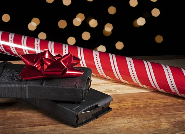 Polymer rifle magazines with Christmas wrapping paper and lights behind