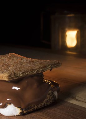 Arkasında aydınlatılmış fener smore ahşap bir yüzeyi ile