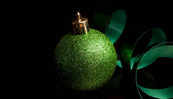 Grüne Schleife Und Weihnachtsschmuck Glitzern Auf Schwarzem Hintergrund — Stockfoto