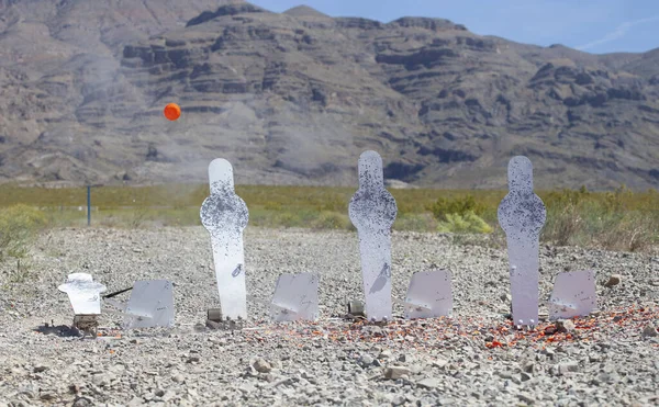 Clay bird released from a steel silhouette after being struck by a shotgun blast