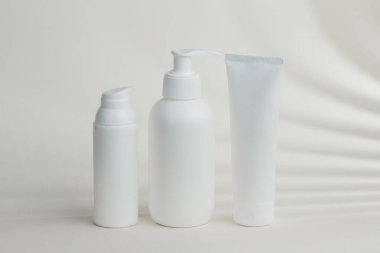 Kozmetik şişeleri ve tüpleri güzellik ürünlerinin tanıtımı için temiz ve minimalist bir zemin oluşturuyor.