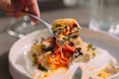 Bir parça gurme ravioli makarnası ve çataldan dökülen sosla bir çatal tutarken. Kaliteli yemekler.