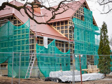 Eski evin yenilenme süreci. Nesne koruyucu bir ağ ile kaplıdır. İnşaat malzemeleri ve destekleyici yapılar. Toparlanma konsepti. Yakın plan..