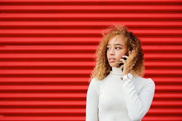 Mladá Krásná Žena Kudrnaté Vlasy Mluví Telefonu Červeném Pozadí — Stock fotografie