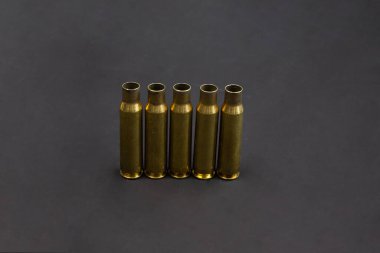 Beş boş kovan yan yana dizilmiş. Siyah arkaplan.