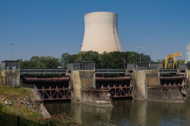 Makine dairesi olan bir hidroelektrik santralinin üç kilidi. Ve arka planda bir nükleer santralin soğutma kulesi..