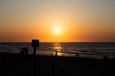 Deniz kenarında romantik bir gün batımı. Dalgaların üzerinde batan güneş.