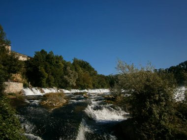 Ren Şelalesi, gürleyen su kütleleriyle ve arka planda Laufen şatosuyla çağlıyor..