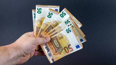 50 Euro 'luk banknotları olan bir adam onları fan şeklinde tutuyor.