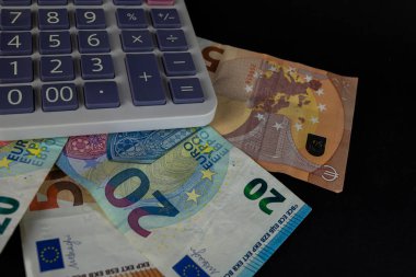 Hesap makinesinin yanında farklı para birimlerinin banknotları