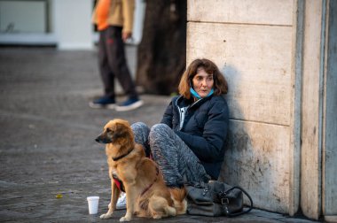 Terni, itali 05 Ekim 2020: Köpekli bir kadın sadaka dileniyor