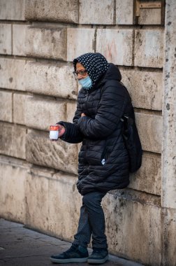 Terni, itali 05 Ekim 2020: Duvara yaslanmış sadaka için yalvaran endişeli kadın