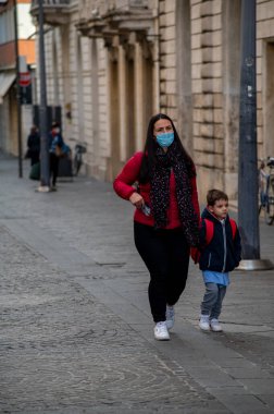 Terni, İtalya 14 Ekim 2020: kızına okula kadar eşlik eden ve maske takan kadın