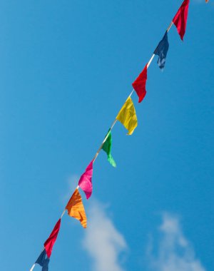 Mavi gökyüzüne karşı çok renkli bayraklar