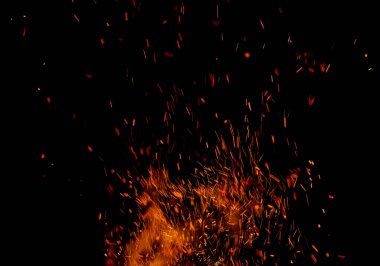 Siyah arkaplanda kıvılcımlar saçan bir ateş alevi