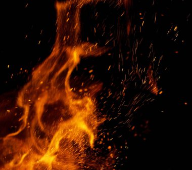 Siyah arkaplanda kıvılcımlar saçan bir ateş alevi