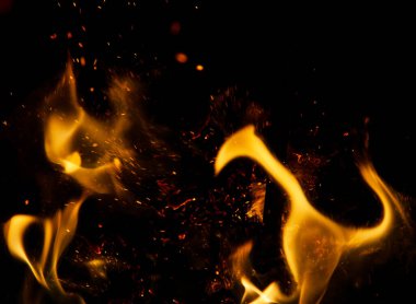 Siyah arkaplanda kıvılcımlar saçan ateş alevleri