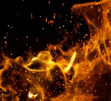 Siyah arkaplanda kıvılcımlar saçan ateş alevleri