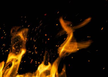 Siyah arkaplanda kıvılcımlar saçan ateş alevleri