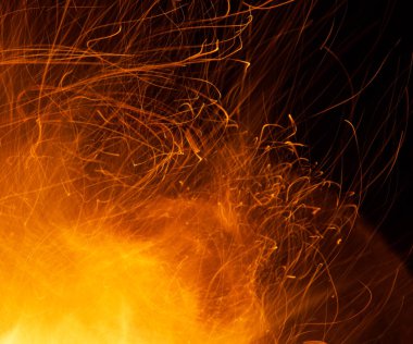 Beyaz arkaplanda kıvılcımlar saçan bir ateş alevi