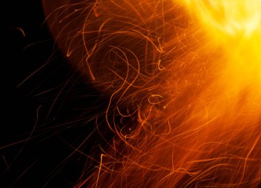 Beyaz arkaplanda kıvılcımlar saçan bir ateş alevi