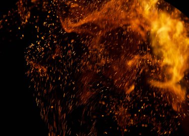 Siyah arkaplanda kıvılcımlar saçan ateş alevleri