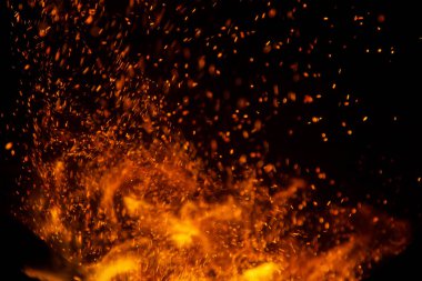 Siyah arkaplanda kıvılcımlar saçan ateş alevleri