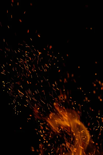 Siyah arkaplanda kıvılcımlar saçan ateş