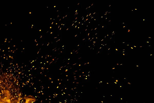 Siyah arkaplanda kıvılcımlar saçan bir ateş alevi