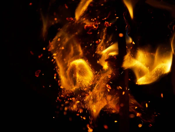 Siyah arkaplanda kıvılcımlar saçan ateş alevleri