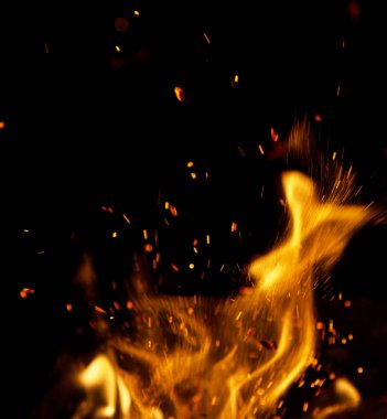 Siyah arkaplanda kıvılcımlar saçan ateş alevleri