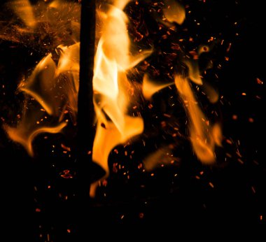 Siyah arkaplanda kıvılcımlar saçan ateş alevleri