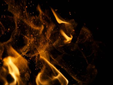 Siyah arkaplanda kıvılcımlar saçan ateş alevleri