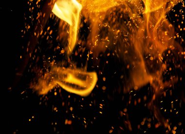 Siyah arkaplanda kıvılcımlar saçan ateş alevleri