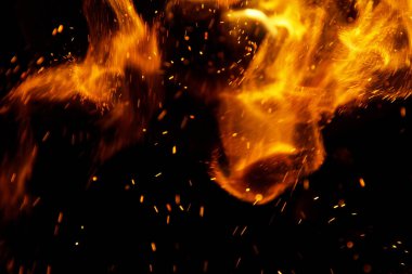 Siyah arkaplanda kıvılcımlar saçan ateş alevleri