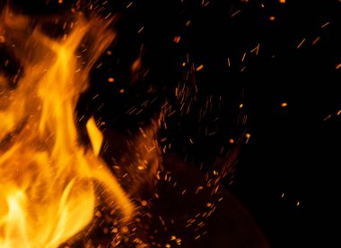 Siyah arkaplanda kıvılcımlar saçan ateş alevleri